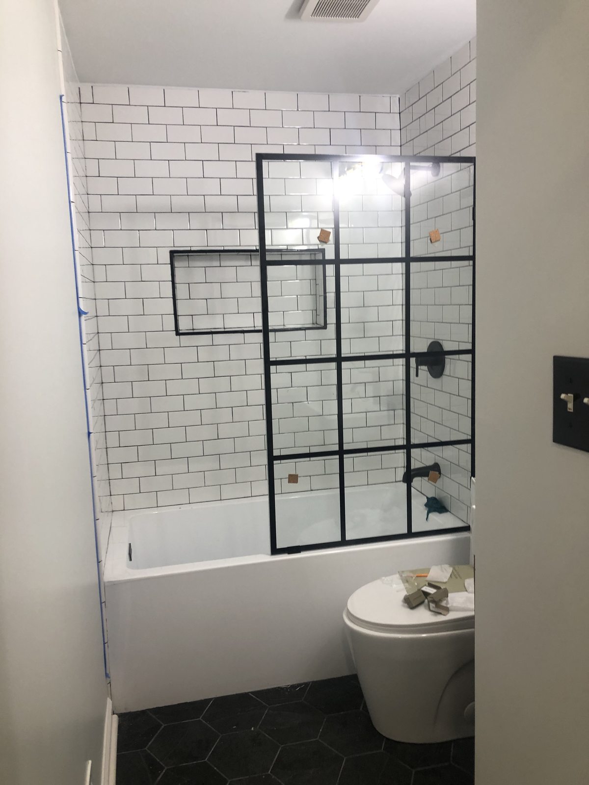 Modern black framed glass shower over tub