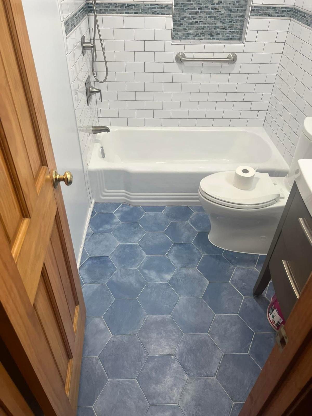 Bathroom with tub and blue hexagon tile floor