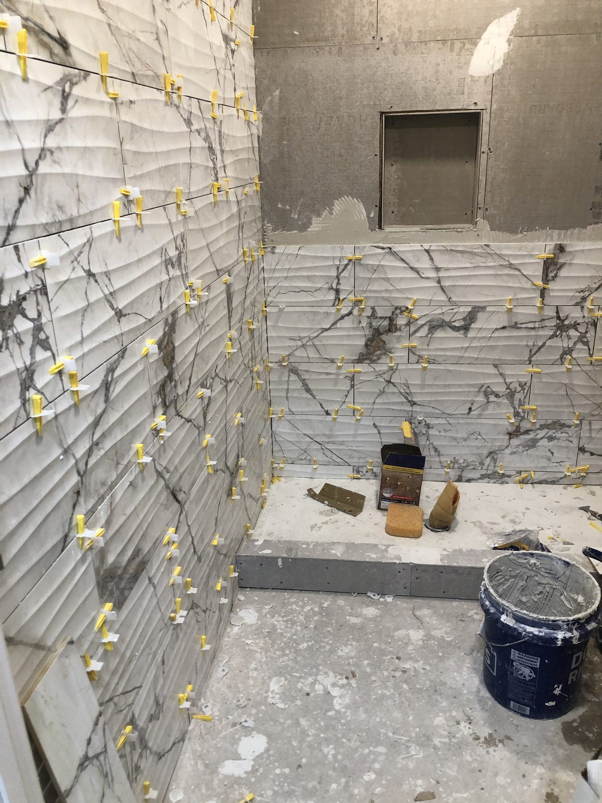 Book-matched marble walls with wave tile