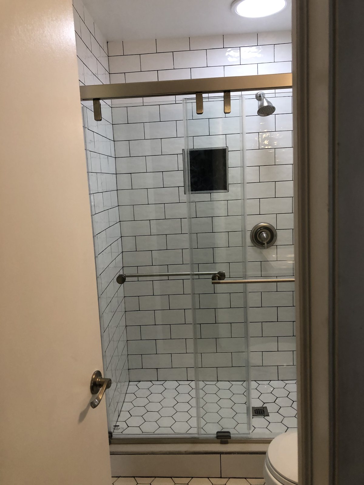 Glass shower enclosure with subway tile